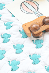 Close-up of hand block printed blue elephants on soft padded cotton playmat