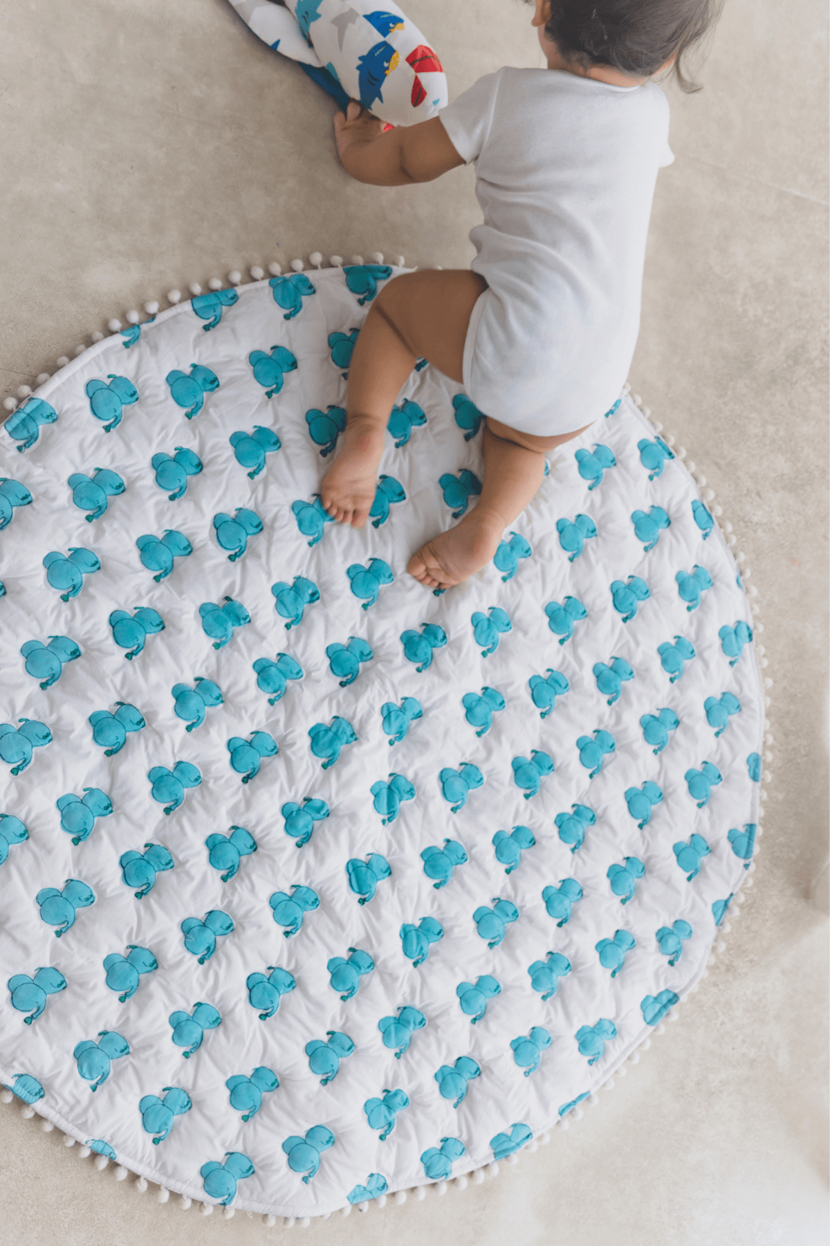 Baby lying on soft padded blue elephant cotton playmat, 40x40 inches