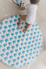 Baby lying on soft padded blue elephant cotton playmat, 40x40 inches