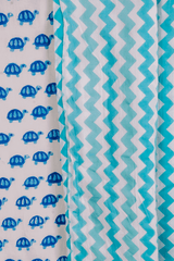 Close-up of tiny blue turtles hand block printed on soft cotton mulmul dohar