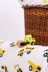 Close-up of hand block printed yellow construction trucks on cotton mulmul baby quilt with wooden toy road roller