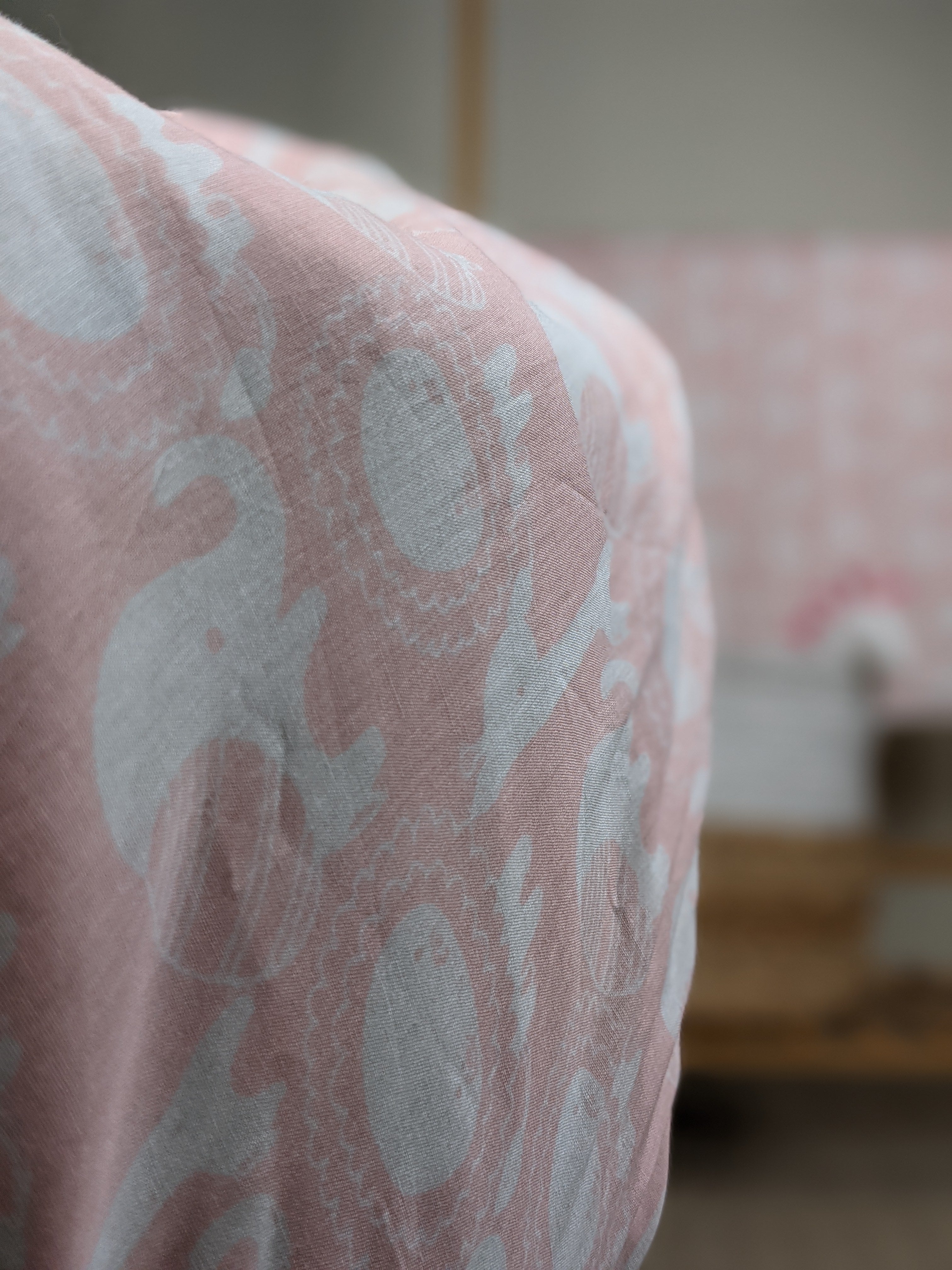 Close-up of jungle animals screen printed on soft pink cotton mulmul dohar