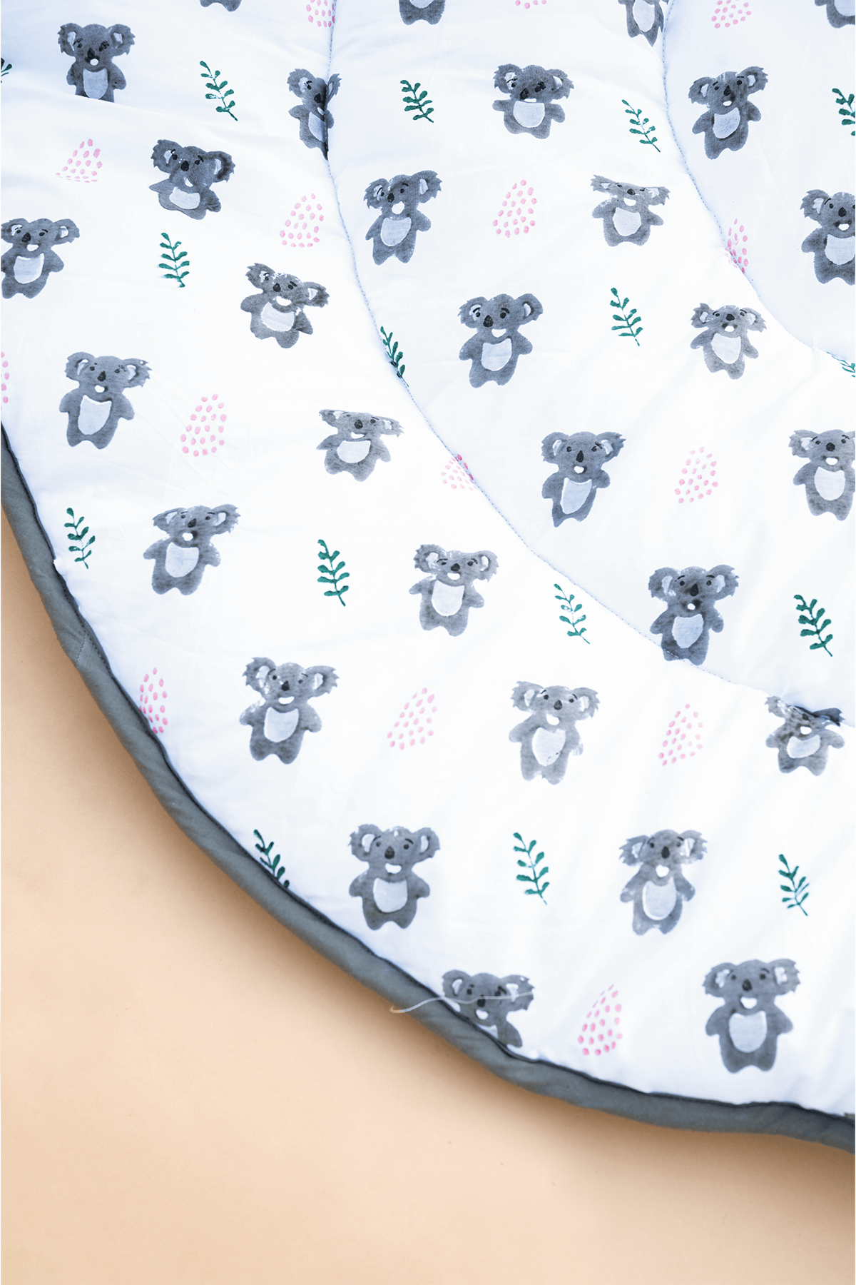 Close-up of hand block printed koalas on soft padded cotton baby playmat
