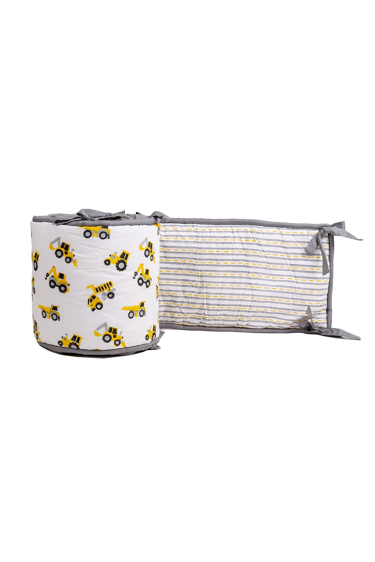 Partly unrolled reversible cot bumper with construction truck print and yellow-grey road stripe reverse