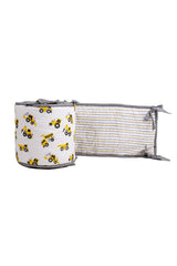 Partly unrolled reversible cot bumper with construction truck print and yellow-grey road stripe reverse