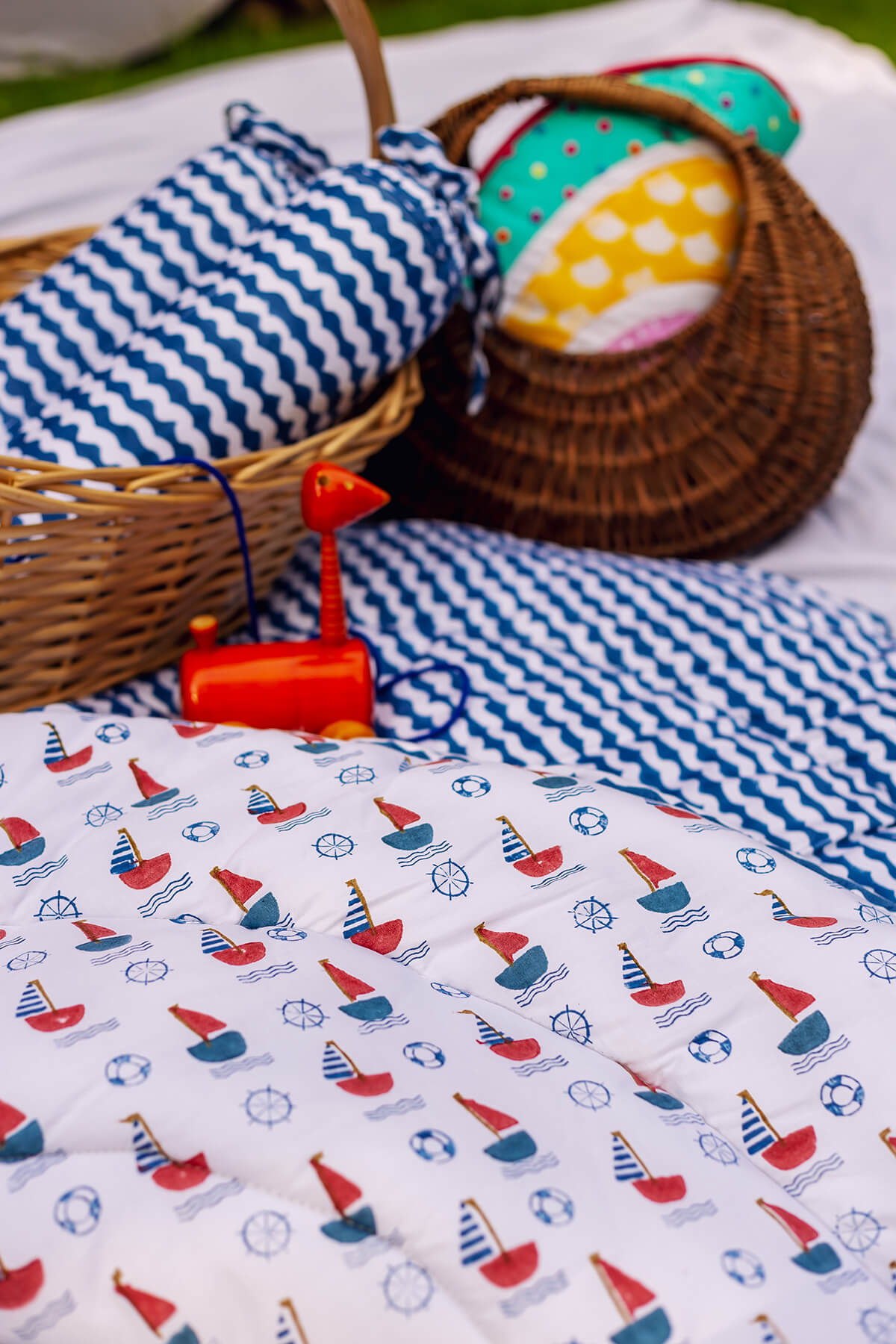 Close-up of hand block printed sailboats on soft padded cotton baby playmat